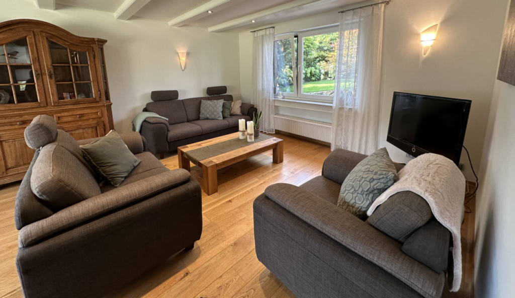 Wohnzimmer mit Couch und Couchtisch, Blick in den Garten